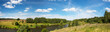 Summer rural panoramic landscape with beautiful river and green forest in sunny day