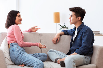 Wall Mural - Asian Girlfriend And Boyfriend Talking And Flirting Sitting At Home