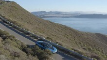 Blue BMW Driving On Coastal Road In Marin Headlands, California. Aerial View