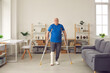 © Studio Romantic - Mature patient successfully undergoes rehabilitation after breaking leg in domestic or car accident. Senior patient with broken leg in plaster cast uses crutches and walks on his own at home