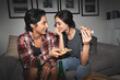 © insta_photos - Two happy young girls laughing, drinking beer, sharing pizza at home party late. Cheerful best friends or couple talking, having fun enjoying eating fast food at night sitting on couch together.