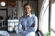 © fizkes - Head shot portrait smiling successful young businessman standing with arms crossed in modern office, happy executive boss startup founder looking at camera, posing for corporate photo alone