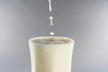 Canvas Print - Glass of fresh vanilla milkshake on a gray background