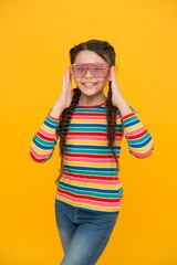 Wall Mural - Trendy Luxury. beauty in glamour glasses. childhood happiness. smiling child on yellow background. casual fashion accessory. party time. happy teen girl with stylish hairstyle. funny kid having fun