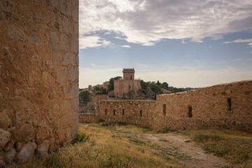 Wall Mural - View of the fortified city of Alarcon with its wall and castle from a watchtower on a cloudy day, Cuenca, Spain