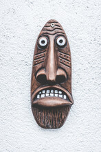 Vertical Shot Of An African Mask Against A Wall