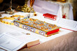 Soft focus of an ornate, religious Greek Orthodox book on a table covered in white fabric