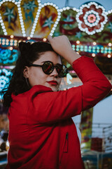 Sticker - Mujer latina con gafas de sol en el atardecer de un parque de diversiones