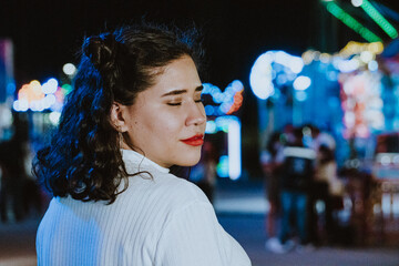 Wall Mural - Mujer latina bonita sonríe en parque de diversiones de noche