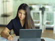© bongkarn - Businesswoman hand writing on notebook while working with laptop on the table