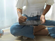 © bongkarn - Female teenager using digital tablet on her lap while legs crossed sitting on the floor