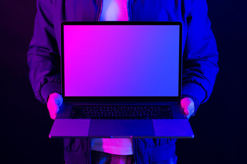 Businessman showing laptop blank screen in neon light