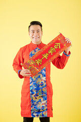 Sticker - Smiling young Asian man showing wall decoration for Lunar New Year celebration with best wishes inscription