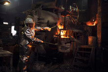 Foundry Worker Checking Molten Steel In Burning Furnace. Iron Production And Melting.