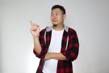 Canvas Print - Young Asian man looked happy thinking and looking up, having good idea. Half body portrait against white wall