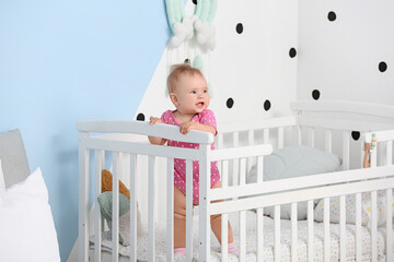 Poster - Cute little baby standing in crib at home