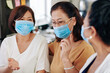 © DragonImages - Group of senior Asian women in medical masks meeting at home due to coronavirus pandemic and discussing news and gossips
