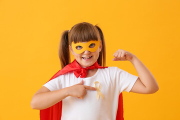 Sticker - Little girl wearing superhero costume and with golden ribbon on color background. Childhood cancer awareness concept