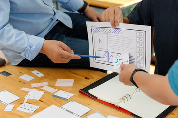 Graphic designers work together with UX UI designer planning application template layout framework for mobile phone computer mobile