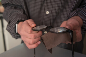 Man cleaning his glasses with a cloth close up with selective focus.