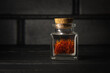 Red saffron spice on a dark background. Aromatic saffron spice bottle.