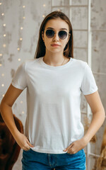 Wall Mural - Stylish girl wearing white t-shirt and sunglasses posing in studio