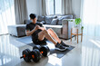 © Auttapol - Exercises at Home. Active Asia man doing Crunch twist in living room.