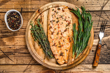 Wall Mural - Cooked salmon fillet with herbs and pink pepper. wooden background. Top view