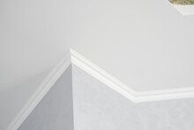 White Ceiling With A White Plinth In A Room With Gray Painted Walls. Decoration Of The Corner Between The Ceiling And The Wall In The Room. Ceiling Molding In The Interior. Detail Of Corner.