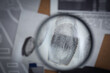 © New Africa - Looking through magnifying glass at fingerprints on detective board, closeup