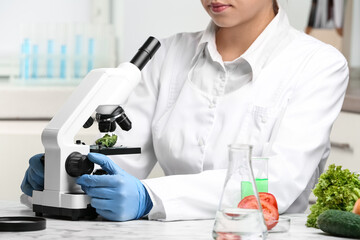 Wall Mural - scientist inspecting broccoli with microscope in laboratory, closeup. poison detection