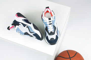 Women's large sneakers and a basketball on a white background.