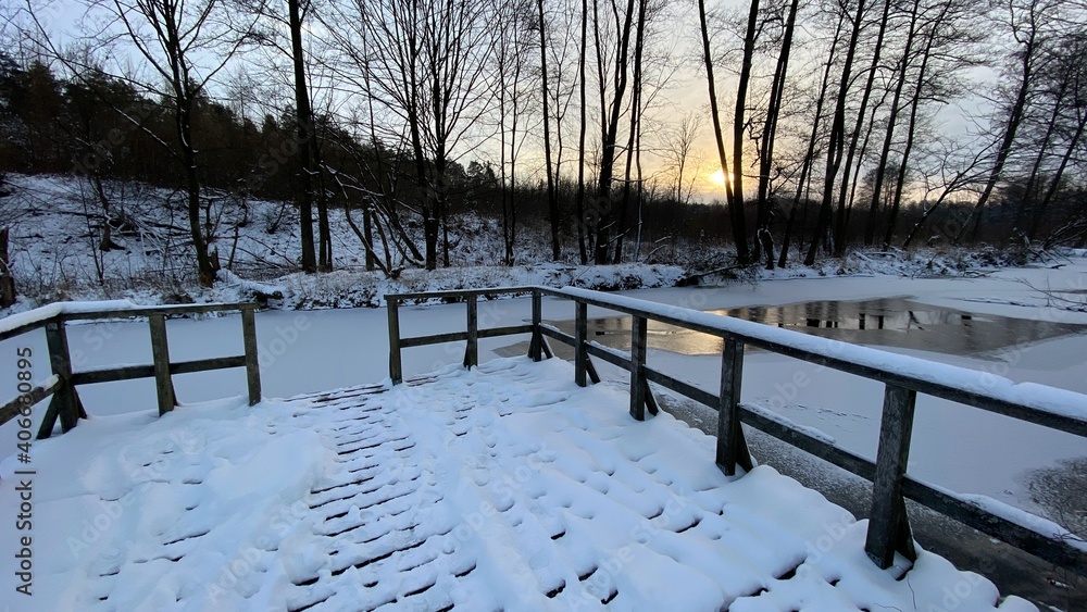 zimowy krajobraz częściowo zamarzniętej rzeki koło Włodawy dużo śniegu niebieskie niebo złota godzina  - obrazy, fototapety, plakaty 