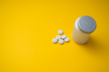  medicine tablets from jars on a yellow background tablets Copy space