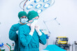 © Thirawatana - Doctors put together surgical gowns. Surgeon in blue surgical gown binds the mouthguard for an emergency.