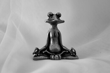 a frog sitting in a lotus position and meditating , monochrome