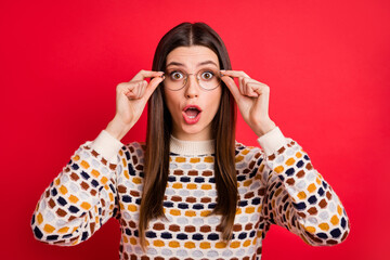 Wall Mural - Portrait of impressed nice girl fingers spectacles open mouth wear colorful sweater isolated on red color background