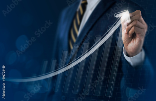 Business growth, boost up business, progress in business or success concept. Businessman is drawing exponential growth graph on dark tone background.