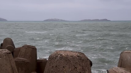 Wall Mural - Waves and rocks in  cloudy day