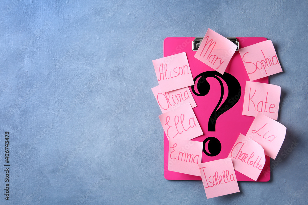 Question mark and paper notes with different baby names on blue ...