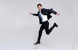 © NaMong Productions - Fun portrait of happy energetic young Asian businessman jumping in mid-air isolated on studio white background.