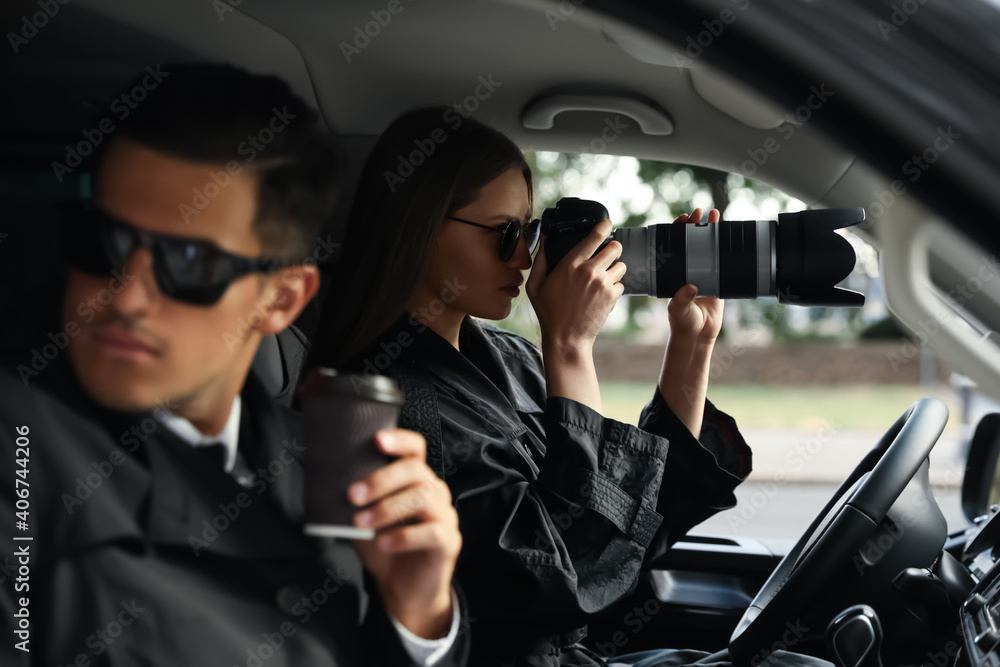 Private detectives with modern camera spying from car - obrazy, fototapety, plakaty 
