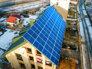 Kyiv, Ukraine - September 12, 2019: Aerial view of new modern two story house cottage with blue shiny solar photo voltaic panels system on the roof. 