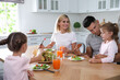 © New Africa - Happy family having breakfast together at table in modern kitchen