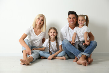 Poster - Happy family sitting on floor near white wall