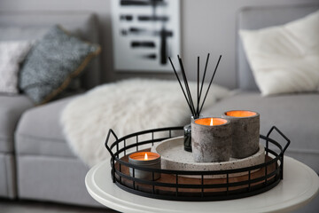 Wall Mural - Candles and aroma reed diffuser on white table near grey sofa