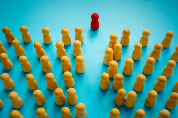 The red figurine moves through the crowd. Be a different and unique leader concept.