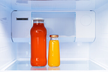 Glass bottle of juice on a fridge shelf