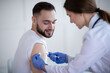 © Prostock-studio - Female medic giving male patient shot of coronavirus vaccine at clinic. Healthcare and medical service concept