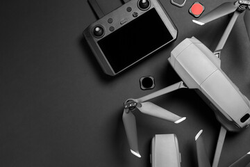Wall Mural - modern drone with camera and video production equipment on black background, flat lay. space for tex